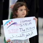 A child holds a banner as she participates in an anti-Syria regime protest held by Bahrainis at...