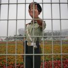 A Chinese security guard asks not to have his photo taken in front of China's National Stadium,...