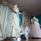 A conservator puts finishing touches to a wedding dress worn by Princess Charlotte when she...