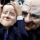 A demonstrator dressed as Rupert Murdoch holds a puppet depicting Britain's Prime Minister David...