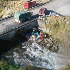 A digger scoops up spilled refuse beside the Makarewa River yesterday. Photo from Environment...