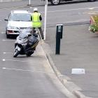 A Dunedin City Council parking officer writes a ticket earlier this year in this file photo.