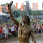 A festival goer covered in mud after wrestling with his friend at the 2009 Glastonbury Festival....