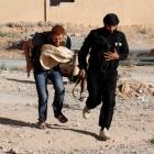 A Free Syrian Army fighter carries bread as he runs with a fellow fighter to avoid snipers loyal...