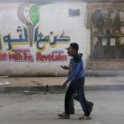 A Free Syrian Army fighter walks past graffiti on a wall along a street in Deir al-Zor. REUTERS...