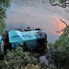 A Fulton Hogan truck lies in Otokia Creek  yesterday.