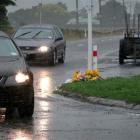 A guard of police officers stand to attention as two hearses carry away the bodies of victims...