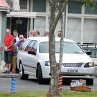 A hearse leaves the funeral. Photo by Craig Baxter