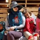 A Jordanian UN volunteer sits with a Syrian refugee child at the Al Zaatri refugee camp in the...