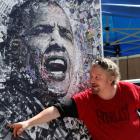 A local artist named 'O' shows off his lithograph featuring President Barack Obama for sale at...