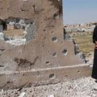 A man looks at one of the walls of the secondary school that activists say was hit by an air...