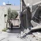 A man walks past damaged buildings in Duma neighbourhood of Damascus, Syria. REUTERS/Bassam Khabieh