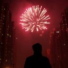 A man watches as fireworks light up the skyline of Shanghai in celebration of Chinese New Year....
