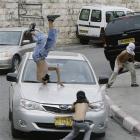 A masked Palestinian protester is hit by a car while throwing rocks in the east Jerusalem...