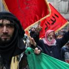 A member of the Free Syrian Army flashes the victory sign during a protest against Syria's...