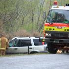 Emergency services crews finish pulling the vehicle up a bank after it crashed near Millers Flat...