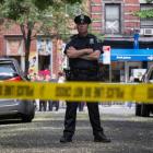 A New York Police Officer stands guard inside a cordoned area at the site of a shooting in...