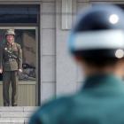 A North Korean soldier (L) and a South Korean soldier keep watch at the truce village of...