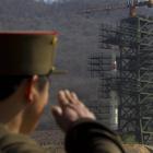 A North Korean soldier salutes in front of the country's Unha-3 rocket, slated for liftoff...