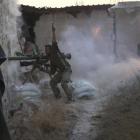 A rebel fighter gestures as he fires his weapon during clashes with forces loyal to Syria's...