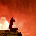 A riot police officer fires rubber bullets at Muslim Brotherhood members and Mohamed Mursi...