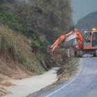 A roading crew works yesterday morning to repair damage to the Southern Scenic Route, reducing...