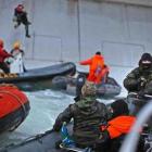 A Russian Coast guard officer is seen pointing a gun at a Greenpeace International activist as...