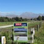 A sold sign is posted on this dairy farm next to the Otekaieke River, owned by Meridian Energy...