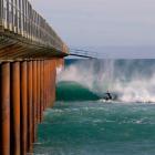 A surfer takes advantage of the conditions near the Tahuna sewage outfall construction jetty...