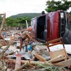 A survivor sorts through debris after a tsunami struck the South East coast villages of Samoa....
