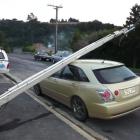 A telephone pole rests against a car owned by Fairfield resident Tony Coward yesterday morning....
