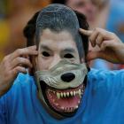 A Uruguay fan poses with a mask of Luis Suarez before the team's match against Colombia. REUTERS...