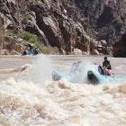 A whirling mass of brown and white foam engulfs boat and passengers.