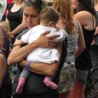 A woman hugs a small child during two-minutes' silence in Queenstown yesterday to mark seven days...