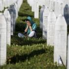 A woman mourns among graves in Memorial Centre Potocari, near Srebrenica, on Saturday as...
