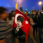 A woman sells Turkish flags with an image of the founder of modern Turkey, Mustafa Kemal Ataturk,...