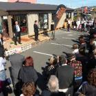 About 150 people watch as a charity three-bedroom home is auctioned at Dunedin's Mitre 10 Mega...