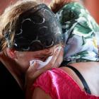 Acquaintances of a flood victim mourn during a religious ceremony before the man's funeral in the...