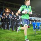 Adam Thomson, of the Highlanders, unveils the new green strip at Carisbrook last Friday night....