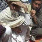Afghan villagers sit near the bodies of children they say were killed during a NATO air strike in...