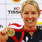 Alison Shanks, of New Zealand, shows off her medal after winning the women's individual pursuit...