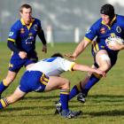 All Black aspirant Tom Donnelly is tackled by halfback Sean Romans during the Otago trial at the...