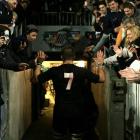 All Black captain Richie McCaw high-fives the hands of fans as he walks down the tunnel after the...