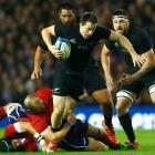 All Black fullback Ben Smith is caught by the Scotland defence. Photo by Getty Images.