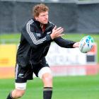 All Blacks flanker Adam Thomson flicks a pass during a training session at Trusts Stadium in...