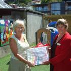 Altrusa member Ella Wilson (left) gives wrapped books to Madelin Lawn, of Plunket. Photo by...