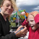 Amberrose Nicol (8), of Millers Flat, gets her face painted by Breana Horrell (14), of Te Anau,...