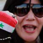 An activist wearing a glove in the colours of the Syrian flag shouts slogans against Israel...