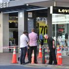 An area outside Wall Street Mall is cordoned off after a glass facade shattered yesterday...