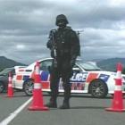 An armed police officer blocks a road into the Urewera Mountains in footage from the documentary ...